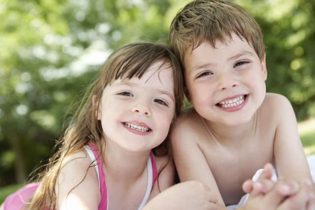 Testvérek egymás mellett mosolyognak